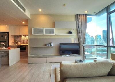 Modern living room with city view, open kitchen, and stylish furniture.