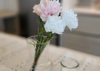 Vase with flowers and candles on the kitchen counter