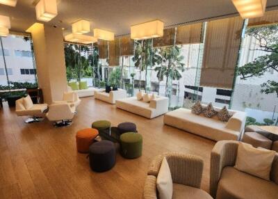 Modern lounge area with white sofas and large windows