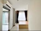 Bedroom with a window, curtain, and air conditioner