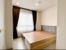 Spacious bedroom with large window and built-in wooden platform bed