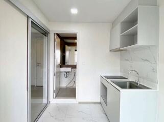 Modern kitchen with built-in cabinets and adjacent bathroom