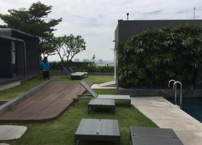 Poolside lounge area with greenery and city view