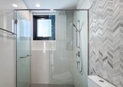 Modern bathroom with shower, toilet, and stylish tiling