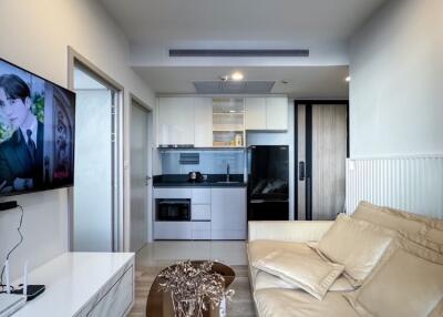 Modern living room with a cozy beige sofa and open kitchen