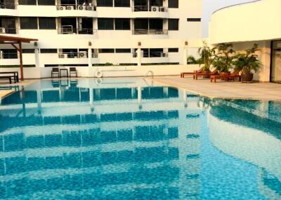 Outdoor swimming pool in front of modern apartment building