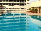 Outdoor swimming pool in front of modern apartment building