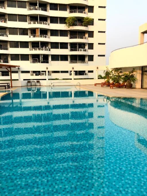 Outdoor swimming pool in front of modern apartment building