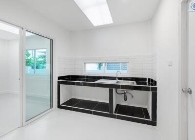 Modern kitchen with large sink basin and black countertops