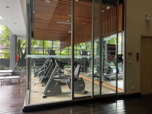 Well-equipped gym with exercise machines and large windows