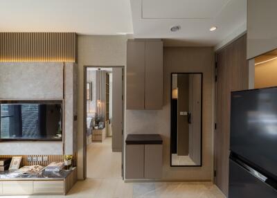 Modern apartment with wall-mounted TV, kitchen area, and sleek furnishings