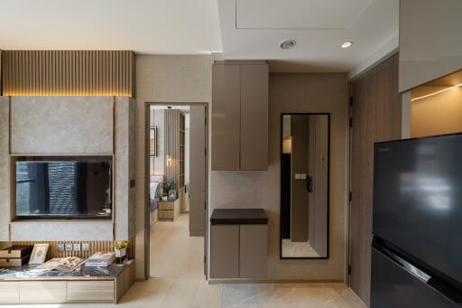 Modern apartment with wall-mounted TV, kitchen area, and sleek furnishings