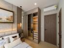 Modern bedroom with wall art, mirrored wardrobe, and air conditioning.