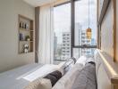 Modern bedroom with a city view, decorative pillows, and a well-lit ambiance