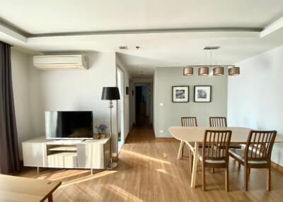 Modern living and dining area with wooden flooring, television, and dining table