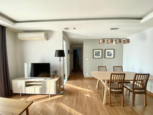 Modern living and dining area with wooden flooring, television, and dining table