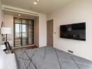 Modern bedroom with a large bed, wall-mounted TV, and a view through a glass door closet.