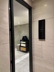 Modern tiled restroom entrance with a view of amenities inside