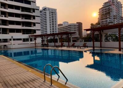 Outdoor swimming pool with seating area at sunset