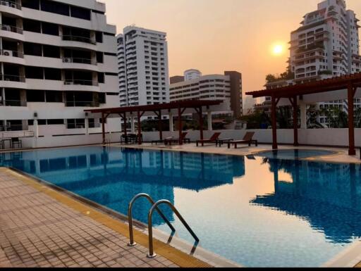 Outdoor swimming pool with seating area at sunset