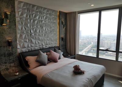 Modern bedroom with textured wall, large window, and city view