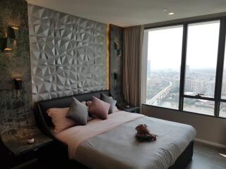 Modern bedroom with textured wall, large window, and city view