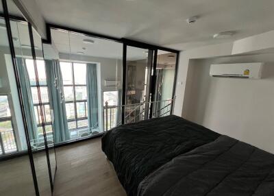 Modern bedroom with floor-to-ceiling windows and mirrored closet