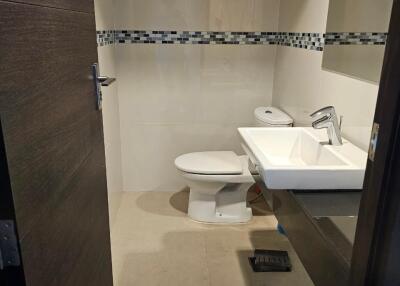 Modern bathroom with sink, toilet, and wall mirror