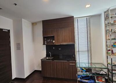 Small modern kitchen with wooden cabinets and dark backsplash