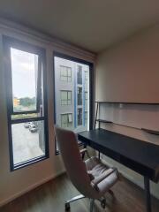 A home office with a desk and chair near a window