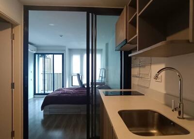 Modern kitchen with view of a bedroom in the background