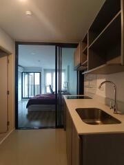 Modern kitchen with view of a bedroom in the background