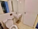 Modern bathroom with white fixtures and tiled walls