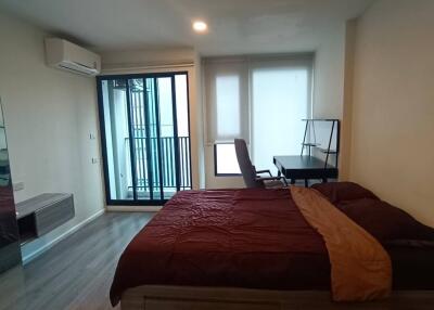 Spacious bedroom with a double bed, desk, and balcony access