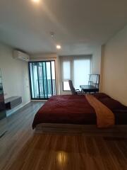 Spacious bedroom with a double bed, desk, and balcony access