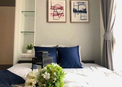 Modern bedroom with decorative pillows and wall art