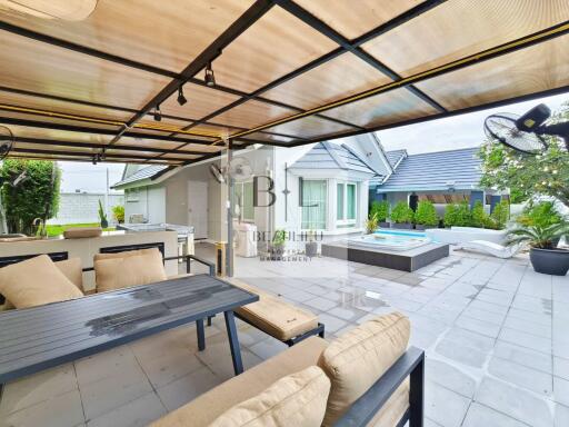 Covered outdoor patio area with seating and a view of a hot tub