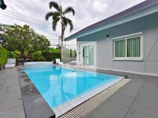 Swimming pool beside a modern house with a backyard