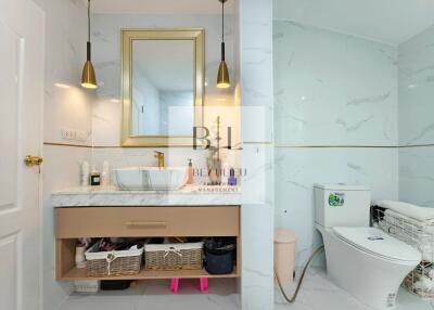 Modern bathroom with gold accents and a vanity with storage