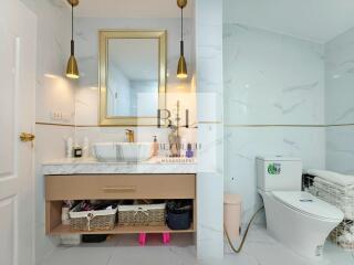 Modern bathroom with gold accents and a vanity with storage