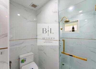 Modern bathroom with glass-enclosed shower and marble tiles