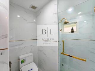 Modern bathroom with glass-enclosed shower and marble tiles