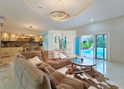 Spacious living room with modern furniture and pool view