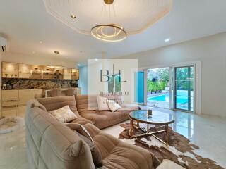 Spacious living room with modern furniture and pool view