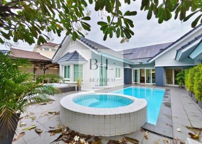 Outdoor view of property with swimming pool and garden