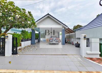 Front view of a property showing a driveway, gated entrance, and a garage