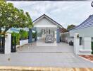 Front view of a property showing a driveway, gated entrance, and a garage