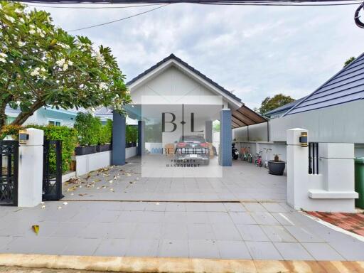 Front view of a property showing a driveway, gated entrance, and a garage