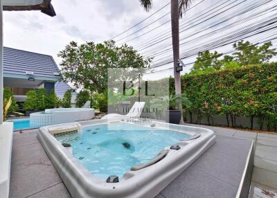 Outdoor jacuzzi area with greenery and pool view