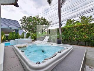 Outdoor jacuzzi area with greenery and pool view